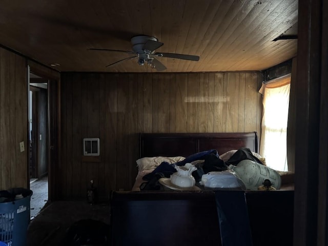 bedroom with ceiling fan, wood walls, and wooden ceiling