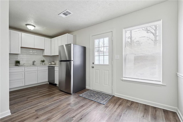 4282 Worth St NW, Acworth, GA 30101 - kitchen featuring a textured ceiling, stainless steel appliances, light countertops, dark wood-type flooring, and visible vents