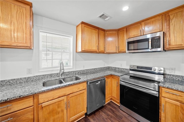 kitchen featuring dark hardwood / wood-style flooring, sink, light stone countertops, and appliances with stainless steel finishes