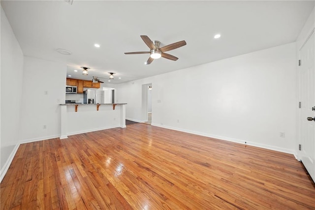 unfurnished living room with ceiling fan and light hardwood / wood-style floors