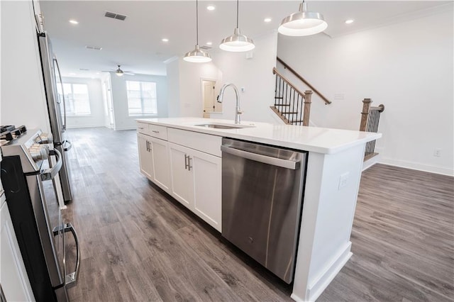 kitchen featuring pendant lighting, sink, range, a kitchen island with sink, and stainless steel dishwasher