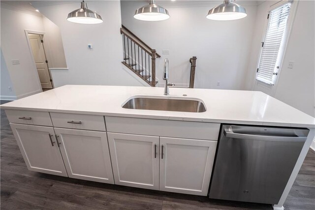 kitchen featuring decorative light fixtures, dishwasher, sink, and white cabinets