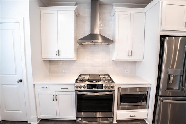 kitchen featuring white cabinetry, appliances with stainless steel finishes, and wall chimney exhaust hood