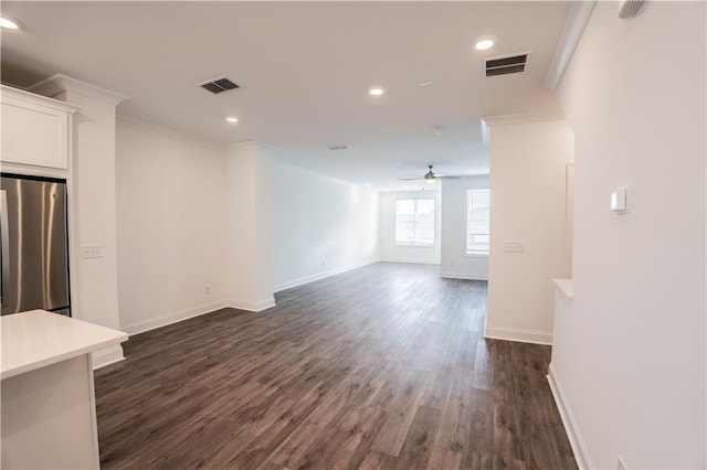 unfurnished living room featuring crown molding, ceiling fan, and dark hardwood / wood-style floors