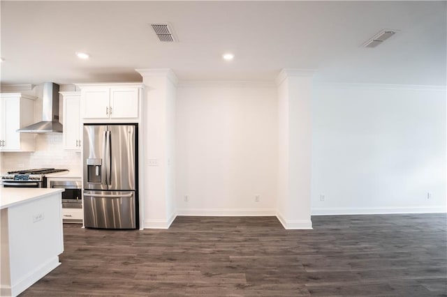 kitchen with white cabinetry, dark hardwood / wood-style flooring, stainless steel appliances, and wall chimney exhaust hood