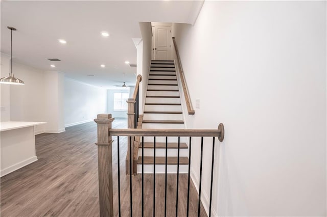 stairway featuring hardwood / wood-style flooring, ceiling fan, and ornamental molding