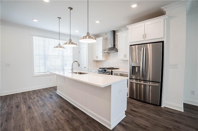 kitchen featuring wall chimney exhaust hood, sink, white cabinetry, appliances with stainless steel finishes, and a kitchen island with sink