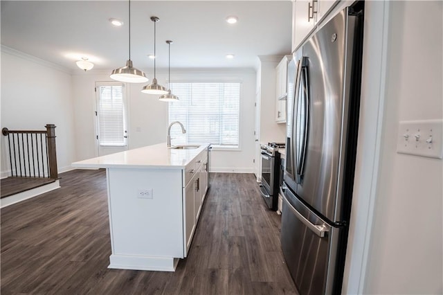 kitchen with sink, appliances with stainless steel finishes, hanging light fixtures, an island with sink, and white cabinets