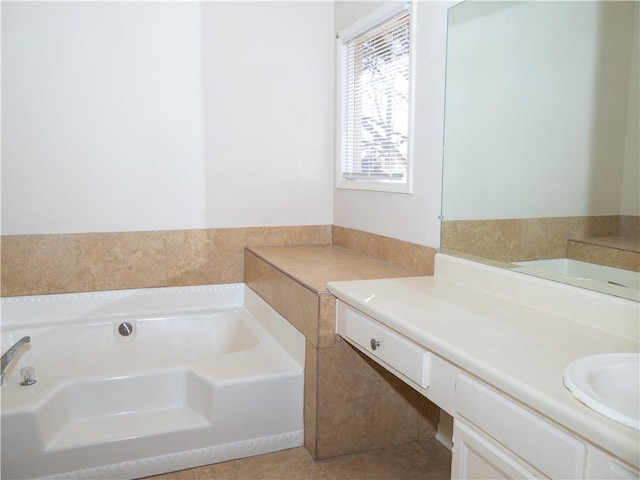 bathroom with tile patterned flooring, vanity, and a bath