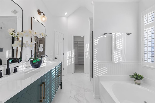 full bath featuring a wealth of natural light, marble finish floor, a bath, and a sink