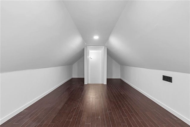 bonus room with visible vents, baseboards, dark wood-style floors, and vaulted ceiling