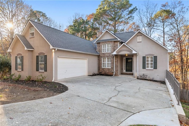 view of front of house featuring stucco siding, an attached garage, and a shingled roof