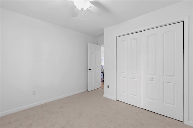 unfurnished bedroom featuring a closet, carpet floors, baseboards, and a ceiling fan