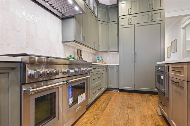 11 Brownson Ct, Acworth, GA 30101 - kitchen with appliances with stainless steel finishes, range hood, light wood-type flooring, backsplash, and light countertops