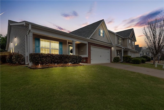 view of front of property with brick siding, a front yard, driveway, and an attached garage