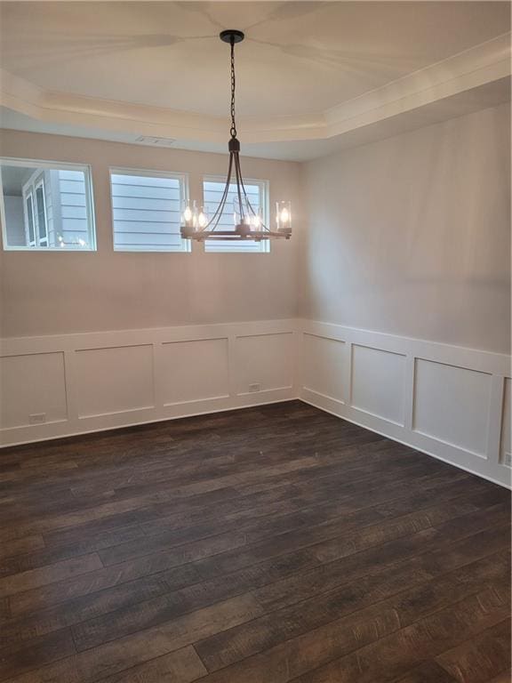 spare room with ornamental molding, dark hardwood / wood-style floors, and a notable chandelier