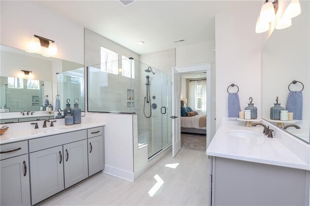 bathroom featuring plenty of natural light, a shower with door, and vanity