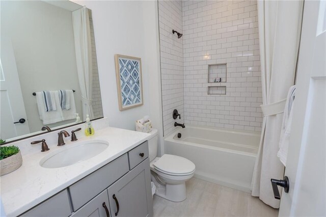 full bathroom featuring shower / tub combo with curtain, vanity, and toilet