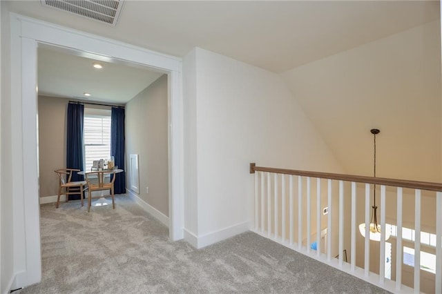 hall with light carpet and vaulted ceiling