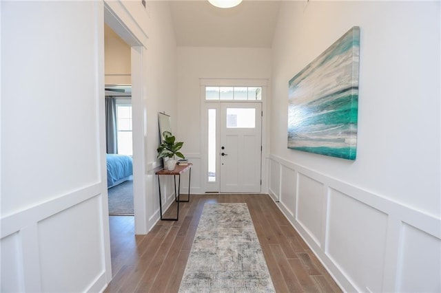 entryway with light hardwood / wood-style floors, a wealth of natural light, and vaulted ceiling