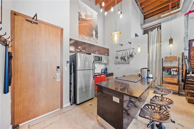 650 Glen Iris Dr NE Unit 26, Atlanta, GA 30308 - kitchen featuring appliances with stainless steel finishes, finished concrete floors, a towering ceiling, dark countertops, and modern cabinets