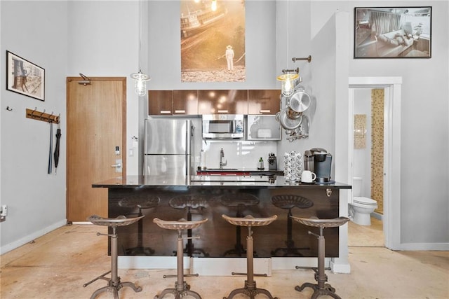 650 Glen Iris Dr NE Unit 26, Atlanta, GA 30308 - kitchen featuring appliances with stainless steel finishes, dark countertops, a kitchen breakfast bar, and hanging light fixtures