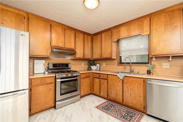 4065 Maxanne Dr NW, Kennesaw, GA 30144 - kitchen with brown cabinetry, appliances with stainless steel finishes, under cabinet range hood, and a sink