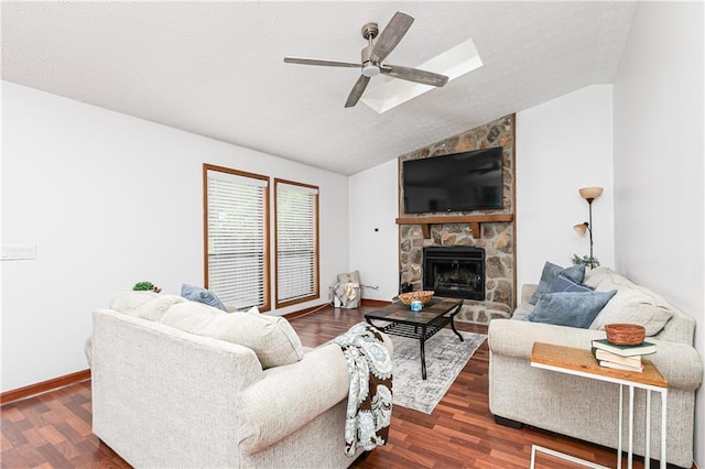 4065 Maxanne Dr NW, Kennesaw, GA 30144 - living room with ceiling fan, a stone fireplace, lofted ceiling with skylight, a textured ceiling, and dark wood-style flooring