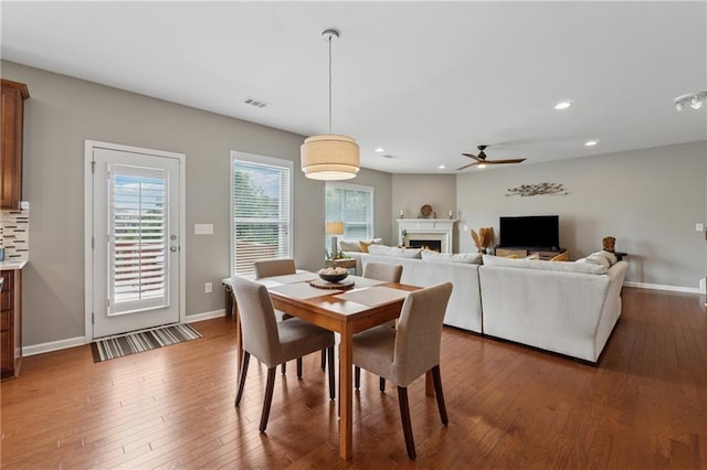 506 Spring View Dr, Woodstock, GA 30188 - dining area with a lit fireplace, ceiling fan, wood-type flooring, and recessed lighting