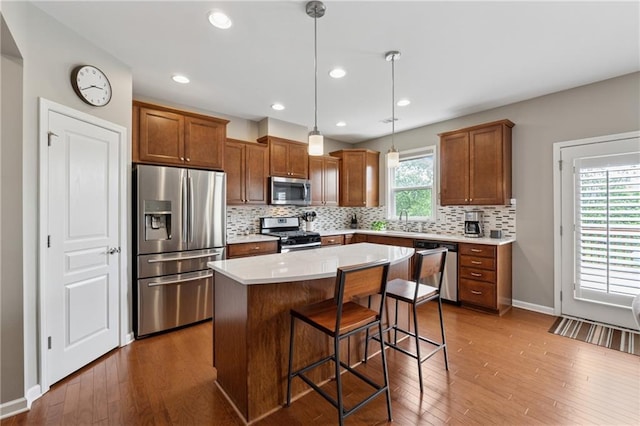 506 Spring View Dr, Woodstock, GA 30188 - kitchen featuring appliances with stainless steel finishes, tasteful backsplash, dark wood finished floors, a breakfast bar area, and a center island