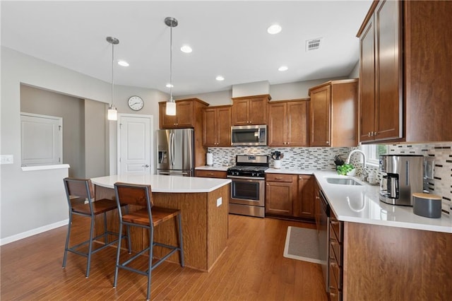 506 Spring View Dr, Woodstock, GA 30188 - kitchen featuring stainless steel appliances, dark wood finished floors, a center island, a kitchen bar, and decorative backsplash