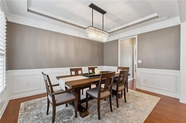 506 Spring View Dr, Woodstock, GA 30188 - dining area with a raised ceiling, a chandelier, wood finished floors, ornamental molding, and a wainscoted wall