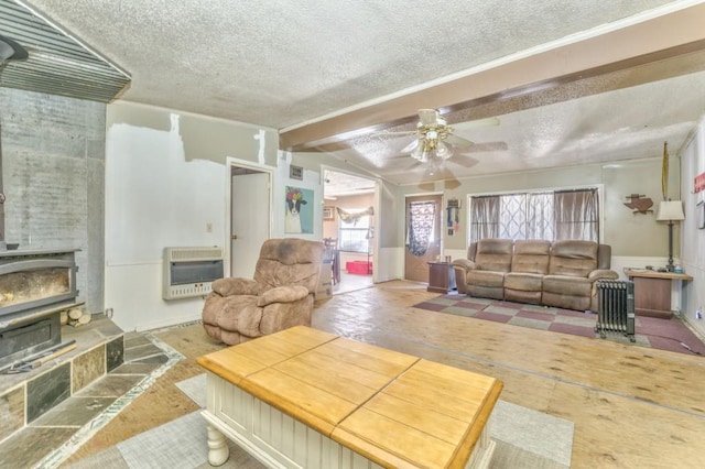 living area with heating unit, a wainscoted wall, and a textured ceiling