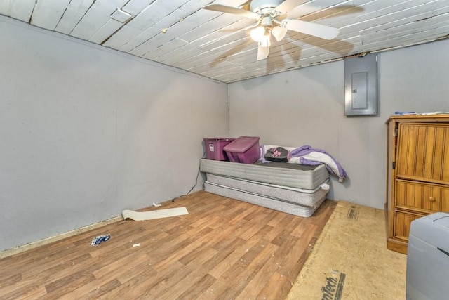 bedroom featuring electric panel, wood ceiling, wood finished floors, and ceiling fan