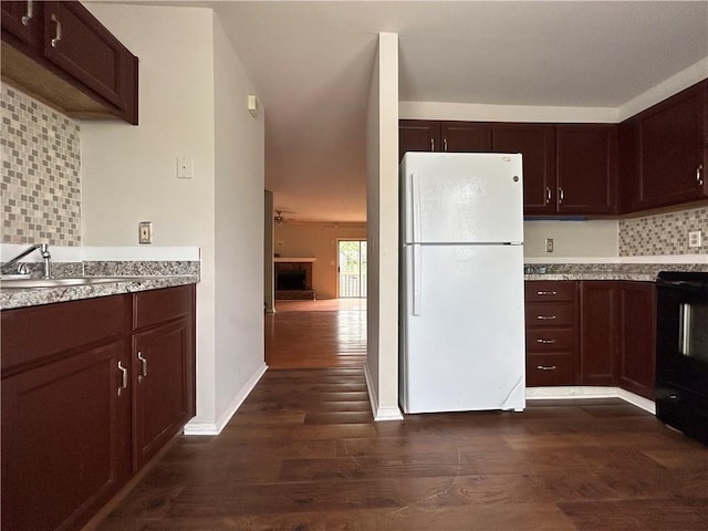 kitchen with sink, dark wood-type flooring, white refrigerator, stove, and decorative backsplash