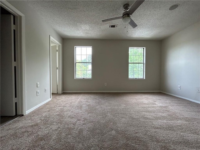 spare room featuring ceiling fan, light colored carpet, and a textured ceiling