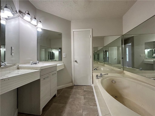 bathroom with vanity, a bath, and a textured ceiling