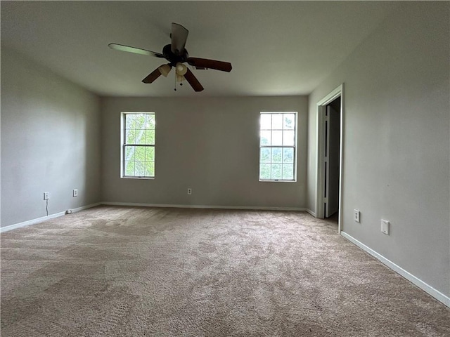 carpeted spare room with ceiling fan