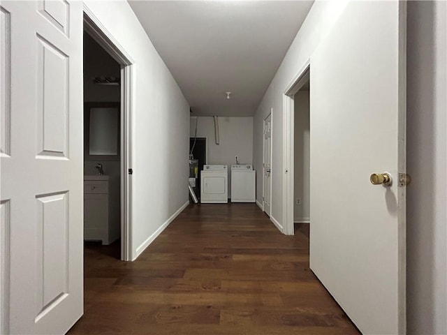 hall featuring washer and clothes dryer, sink, and dark wood-type flooring