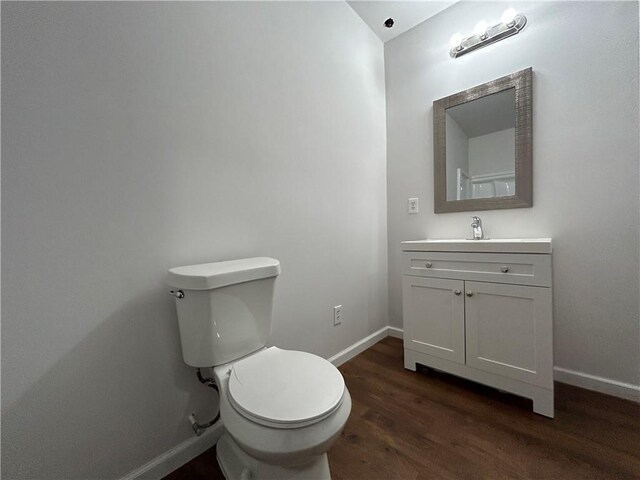 bathroom with vanity, toilet, and wood-type flooring