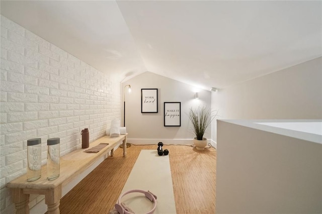 cinema room with brick wall, baseboards, and lofted ceiling