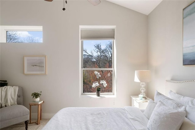 carpeted bedroom featuring multiple windows and lofted ceiling