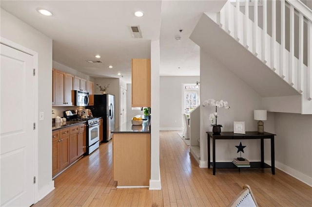 kitchen featuring dark countertops, light wood-style flooring, visible vents, and stainless steel appliances