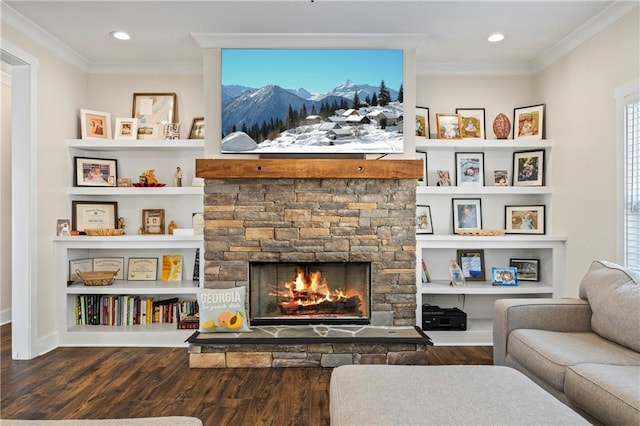 living room with a stone fireplace, ornamental molding, wood finished floors, and built in features