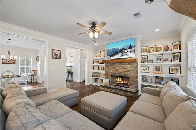 living room with visible vents, dark wood finished floors, a stone fireplace, and ornamental molding