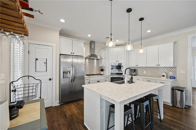 kitchen featuring a kitchen island with sink, stainless steel appliances, dark wood-style flooring, white cabinetry, and wall chimney exhaust hood