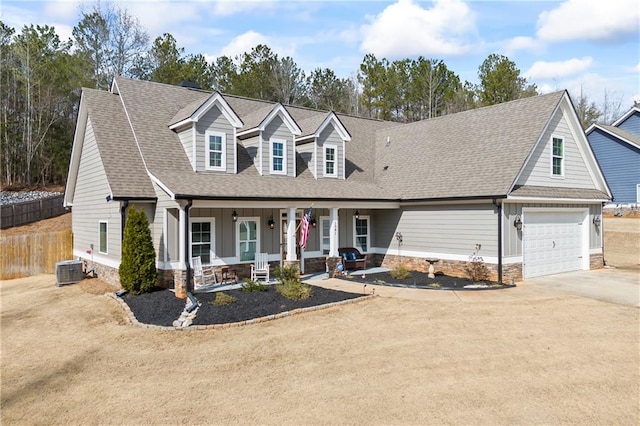 view of front of home with a shingled roof, concrete driveway, covered porch, fence, and a garage