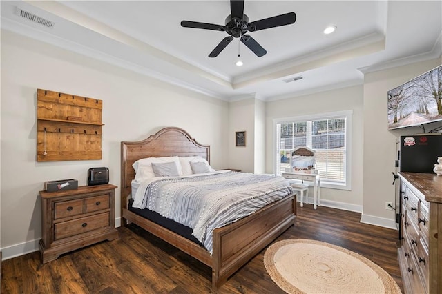 bedroom with visible vents, a raised ceiling, and dark wood-style flooring