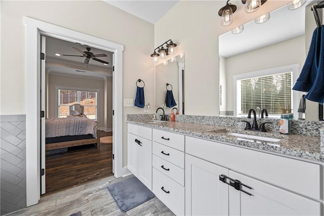 full bath featuring double vanity, a sink, ensuite bath, and wood finished floors