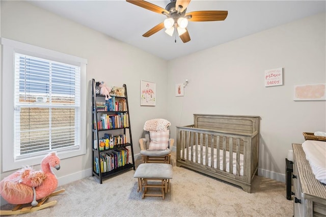 bedroom featuring a crib, carpet flooring, and baseboards